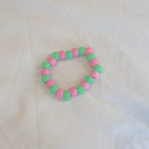 Pink and green kids bracelet with stretchy silver elastic string
